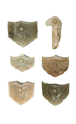 Lot 20 - FIVE INDIAN CARVED JADE MOUNTS FOR DAGGER SCABBARDS AND A CARVED GEM-SET JADE GRIP FOR A KNIFE
