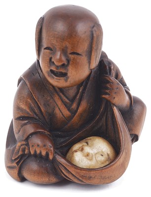 Lot 115 - WOOD NETSUKE OF A BOY WITH A MASK IN A FUROSHIKI
