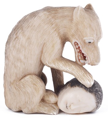 Lot 133 - ~STAINED IVORY NETSUKE OF A WOLF WITH SEVERED HUMAN HEAD