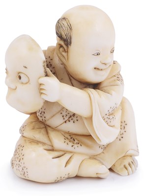 Lot 136 - ~IVORY NETSUKE OF A BOY HOLDING A MASK OF HYOTTOKO