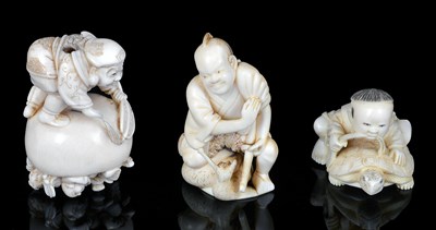 Lot 149 - A JAPANESE IVORY NETSUKE OF A BOY AND MINOGAME