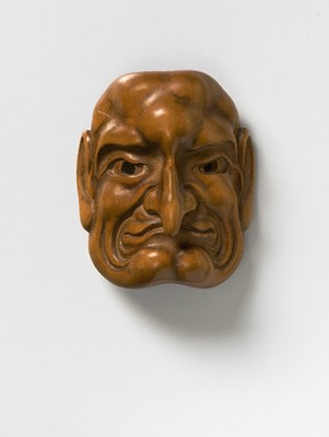 Lot 57 - A JAPANESE MASK NETSUKE OF A LONG NOSED MAN