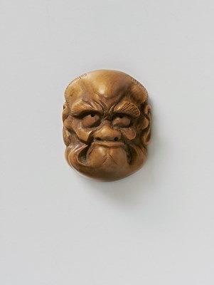 Lot 202 - A JAPANESE MASK NETSUKE OF A FROWNING MAN