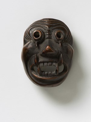 Lot 226 - A JAPANESE MASK NETSUKE OF A GOGGLE EYED GHOUL WITH FANGS