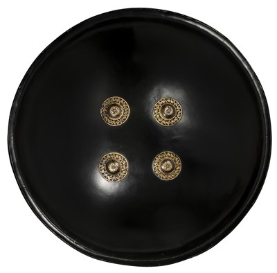 Lot 76 - AN INDIAN BLACK LACQUERED BUFFALO HIDE SHIELD (DHAL), 18TH/19TH CENTURY, POSSIBLY BIKANER