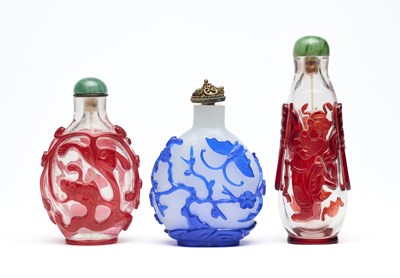Lot 82 - THREE CHINESE CARVED OVERLAY GLASS SNUFF BOTTLES
