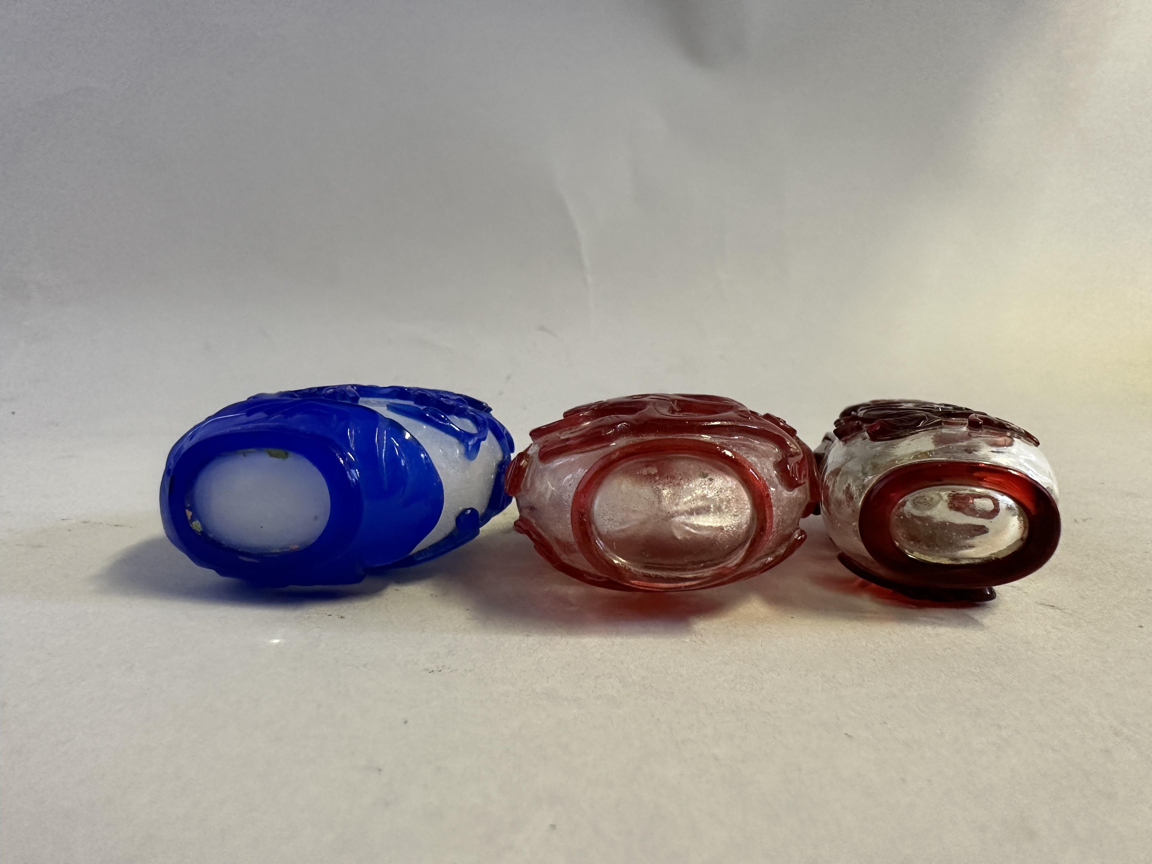 Lot 82 - THREE CHINESE CARVED OVERLAY GLASS SNUFF