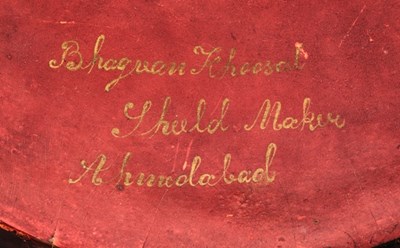 Lot 109 - AN INDIAN HIDE SHIELD (DHAL), 19TH CENTURY, SIGNED BHAGUAN KHOOSALOA, AHMEDABAD