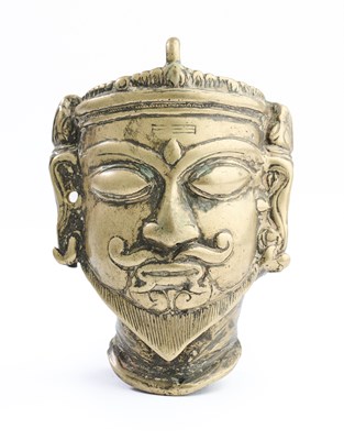 Lot 422 - A SMALL BRASS MASK OF SIVA, MAHARASHTRA, CIRCA 18TH CENTURY
