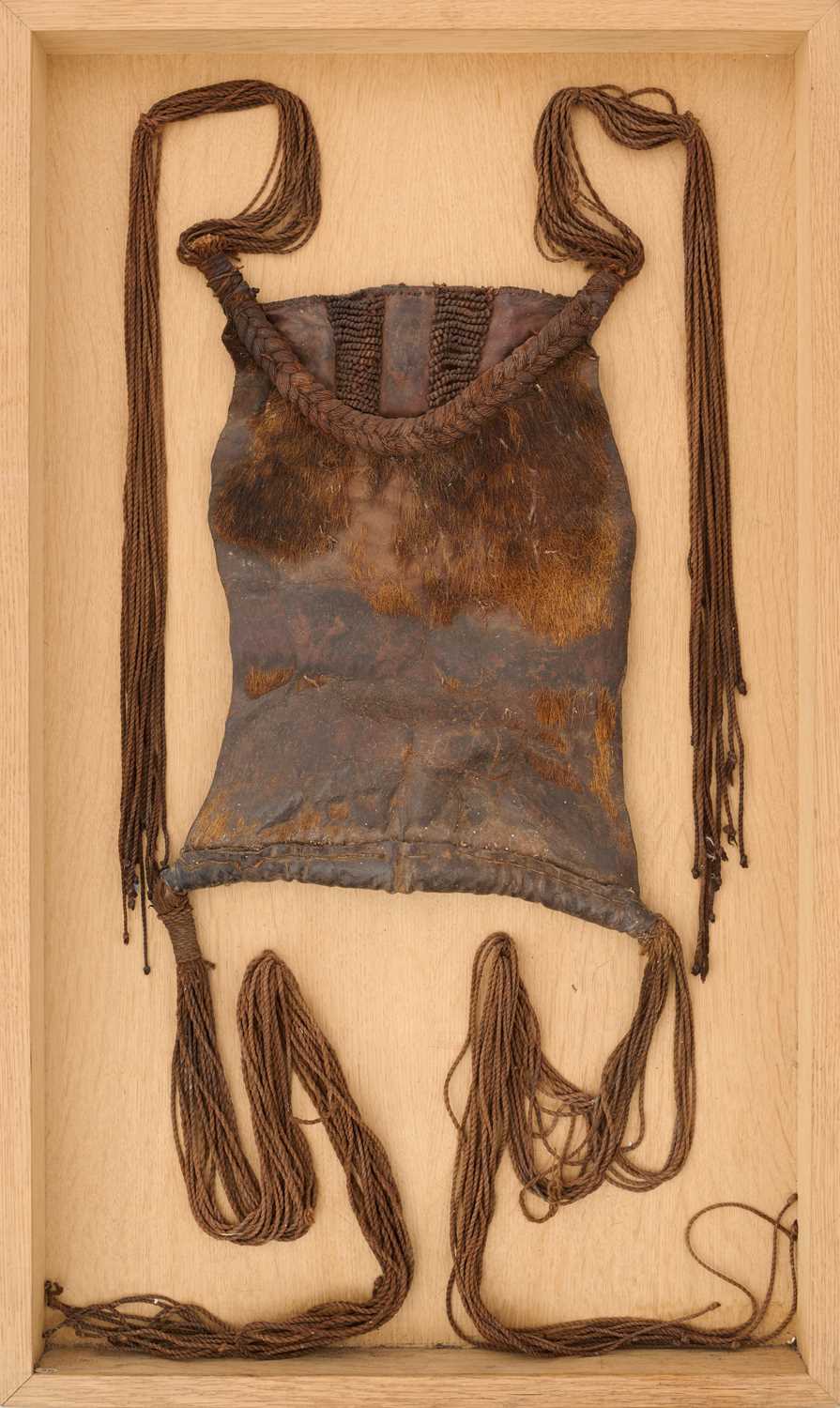 Lot 525 - AN AFRICAN (TUAREG) LEATHER BAG, AND A NAGA DAO HOLDER AND BELT, BOTH LATE 19TH/EARLY 20TH CENTURY