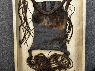 Lot 525 - AN AFRICAN (TUAREG) LEATHER BAG, AND A NAGA DAO HOLDER AND BELT, BOTH LATE 19TH/EARLY 20TH CENTURY