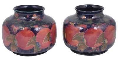 Lot 51 - A NEAR PAIR OF MOORCROFT 'POMEGRANATE' SQUAT VASES