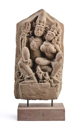 Lot 136 - A PINK SANDSTONE STELE DEPICTING UMA-MAHESVARA, PROBABLY RAJASTHAN, INDIA, 11TH/12TH CENTURY