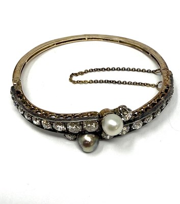 Lot 392 - VICTORIAN PEARL AND DIAMOND HINGED BANGLE, 1890s