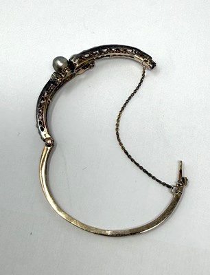 Lot 392 - VICTORIAN PEARL AND DIAMOND HINGED BANGLE, 1890s