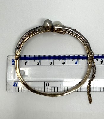 Lot 392 - VICTORIAN PEARL AND DIAMOND HINGED BANGLE, 1890s