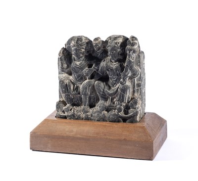 Lot 89 - A GANDHARA GREY SCHIST RELIEF DEPICTING HARITI AND PANCHIKA, NORTH-WESTERN PAKISTAN, 3RD/4TH CENTURY