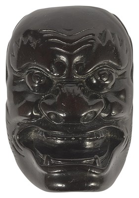 Lot 372 - ~A JAPANESE EBONY MASK NETSUKE OF A FIERCE ONI